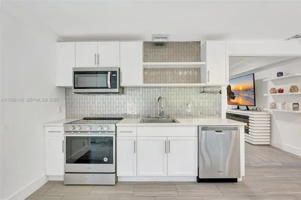 a kitchen with white cabinets stainless steel appliances and sink