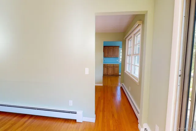 a view of a hallway with wooden floor and staircase