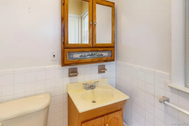 a bathroom with a sink a toilet and mirror