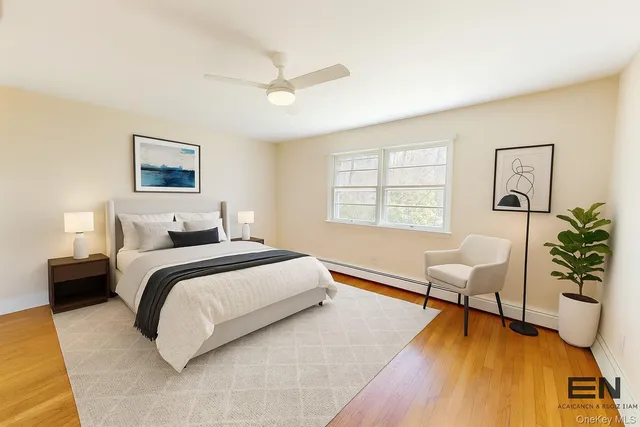 a spacious bedroom with a bed a couch chair and a potted plant