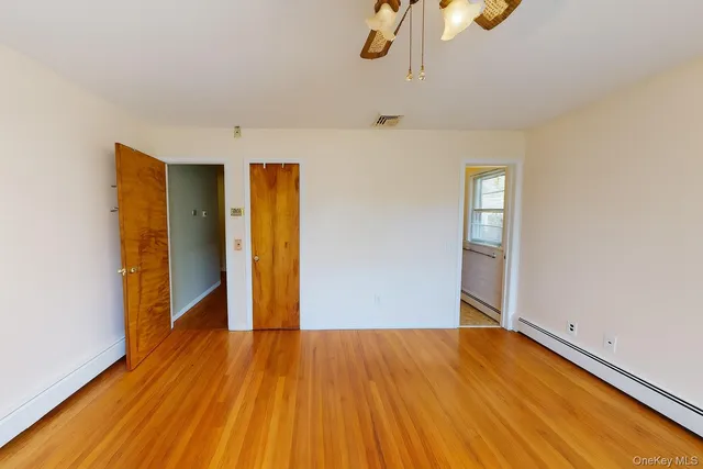 a view of empty room with wooden floor
