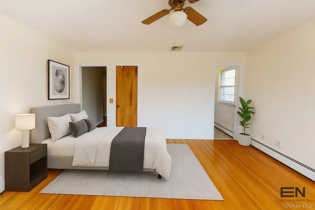a bedroom with a bed lamp and a potted plant