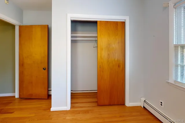 a view of a bedroom with wooden floor and entrance