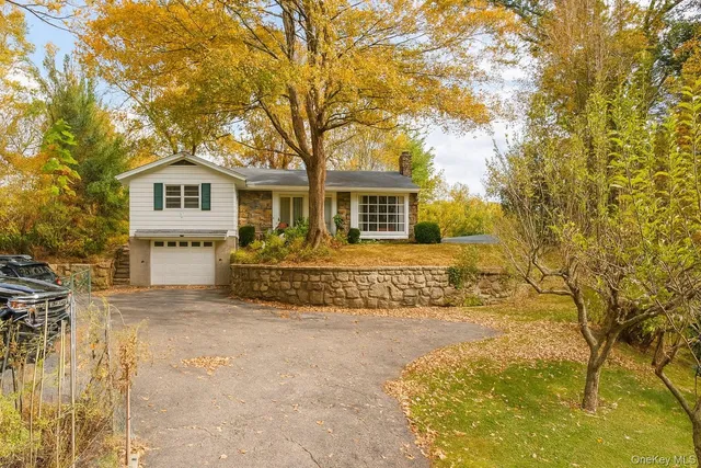 a front view of a house with a garden and trees