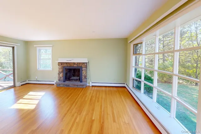 a view of empty room with wooden floor and fireplace