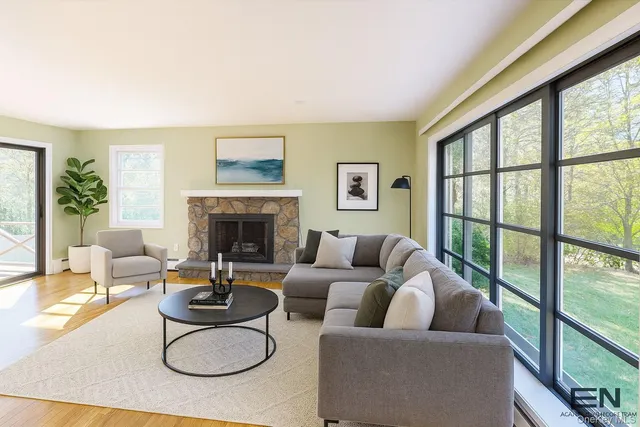 a living room with furniture a fireplace and a floor to ceiling window