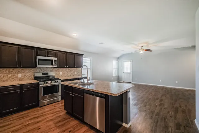 a kitchen with stainless steel appliances granite countertop a sink stove and refrigerator
