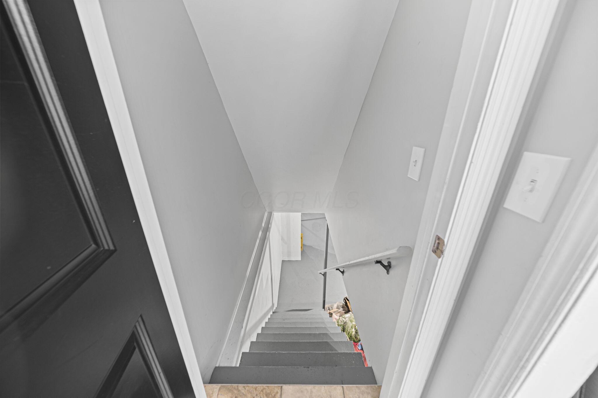 6344 Post Road Dublin, OH 43017 - Photo 25 of 45 Stairwell featuring light gray wall paint, white trim, a white handrail, and dark painted steps