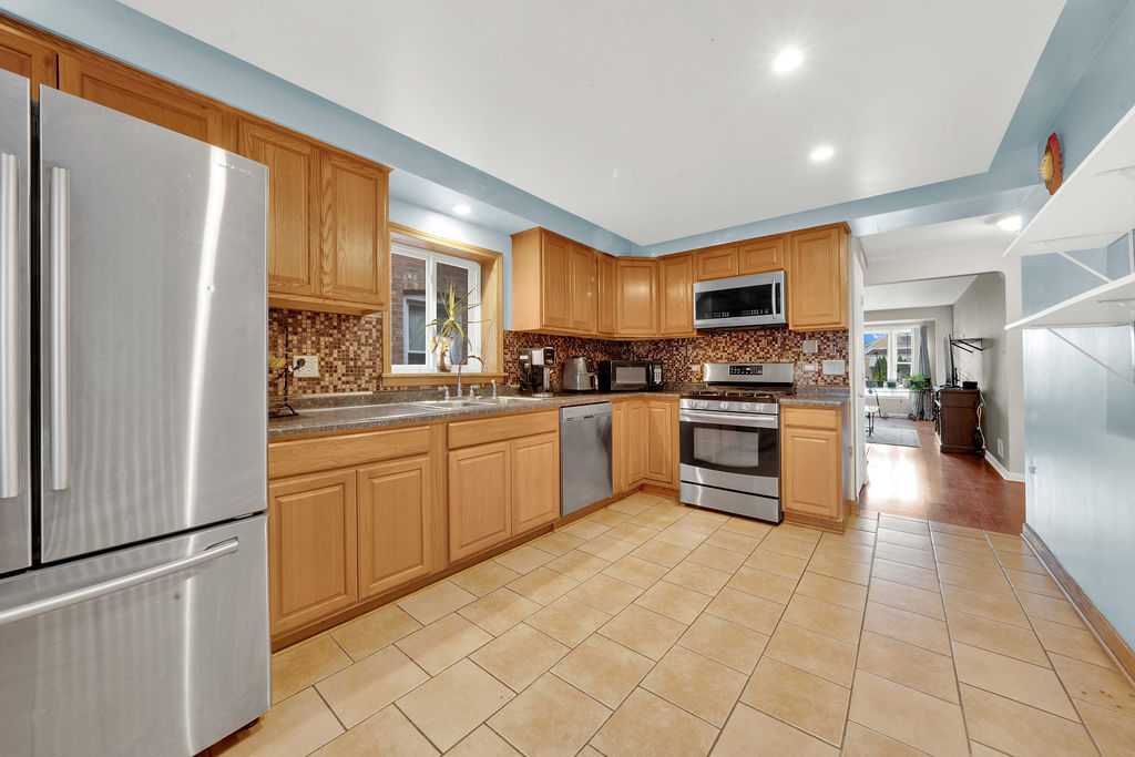 7234 South Ridgeway Avenue Chicago, IL 60629 - Photo 5 of 27 a kitchen with stainless steel appliances granite countertop a refrigerator and a stove top oven
