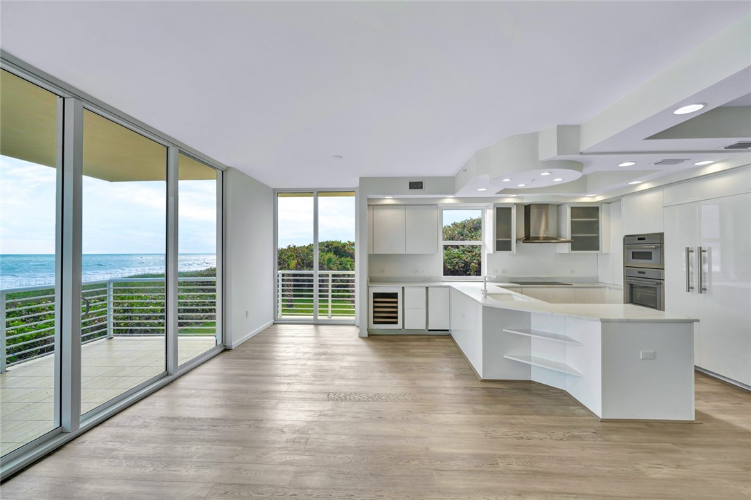 a large kitchen with kitchen island large windows and wooden floors