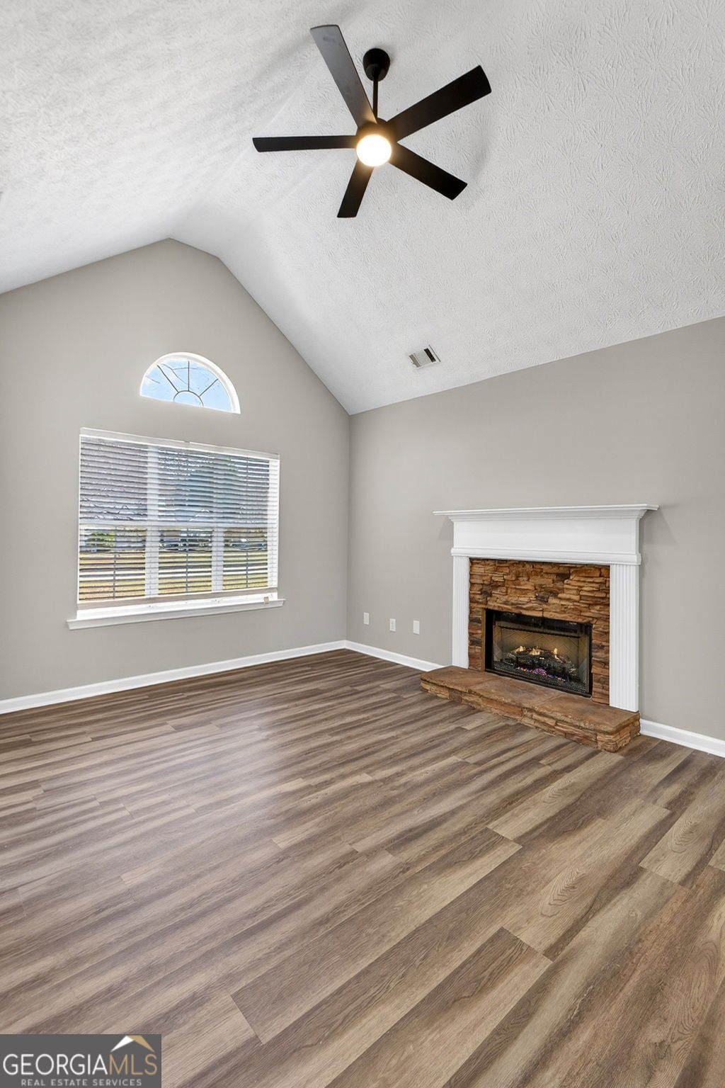 224 Stillwater Court Hampton, GA 30228 - Photo 16 of 44 an empty room with chandelier fan and windows