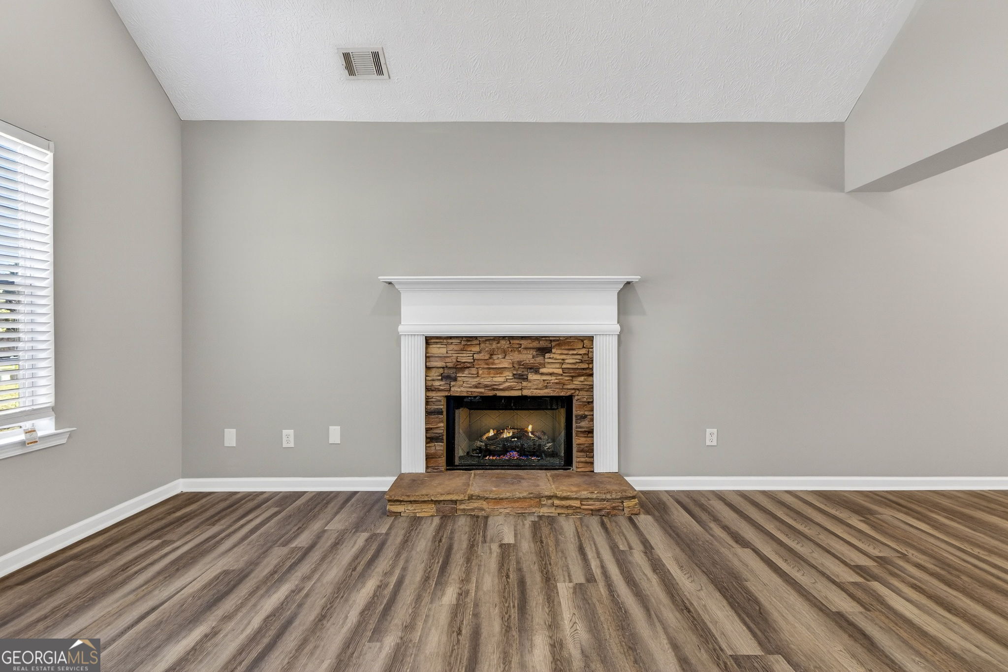 224 Stillwater Court Hampton, GA 30228 - Photo 17 of 44 an empty room with fireplace and wooden floor