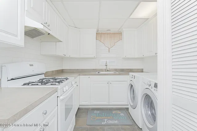 a kitchen with granite countertop white cabinets and white appliances