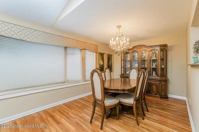 a bedroom with a bed a dresser and potted plant