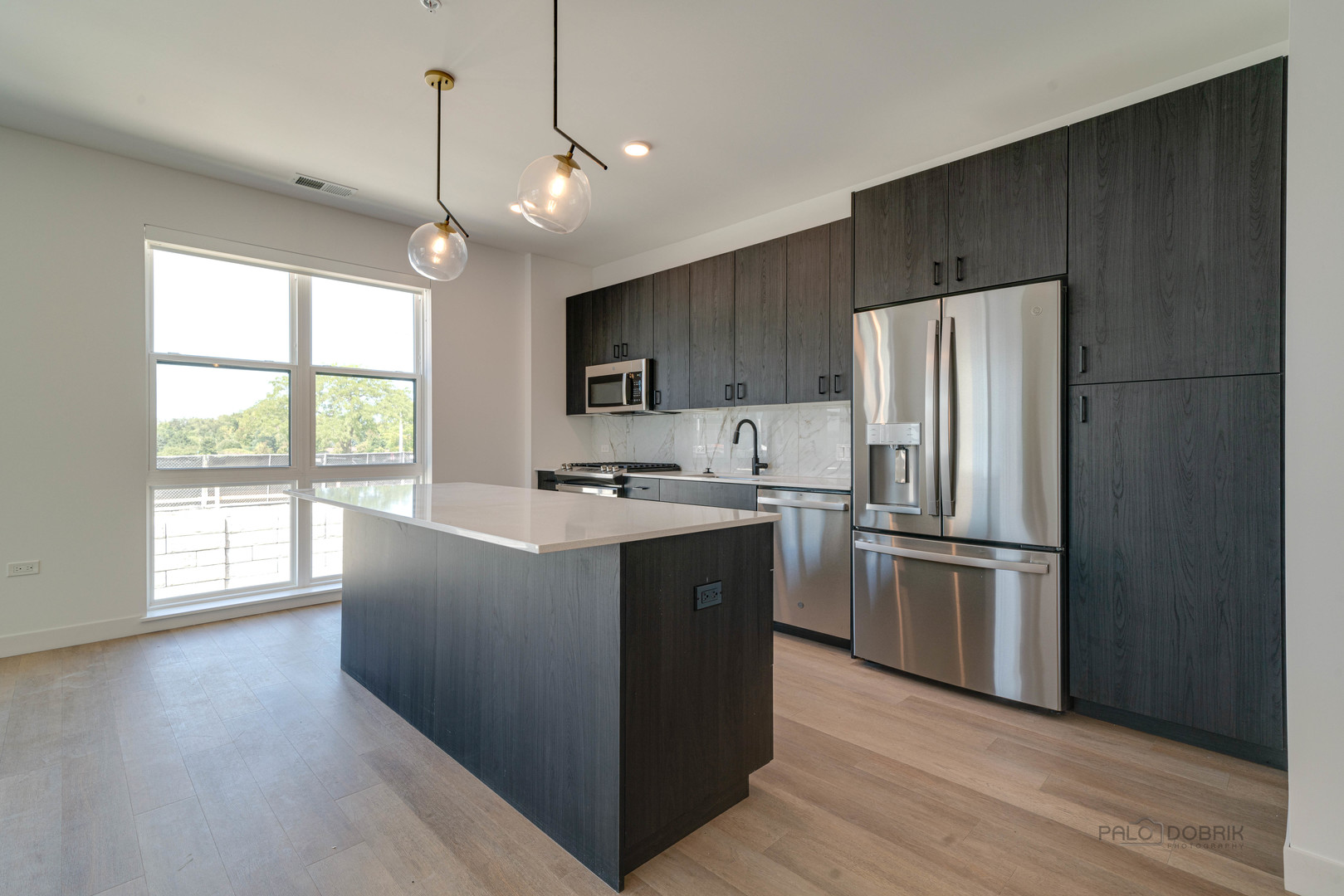 750 Hawthorn Row, Unit 4166 Vernon Hills, IL 60061 - Photo 11 of 24 a kitchen with kitchen island wooden floors appliances and window