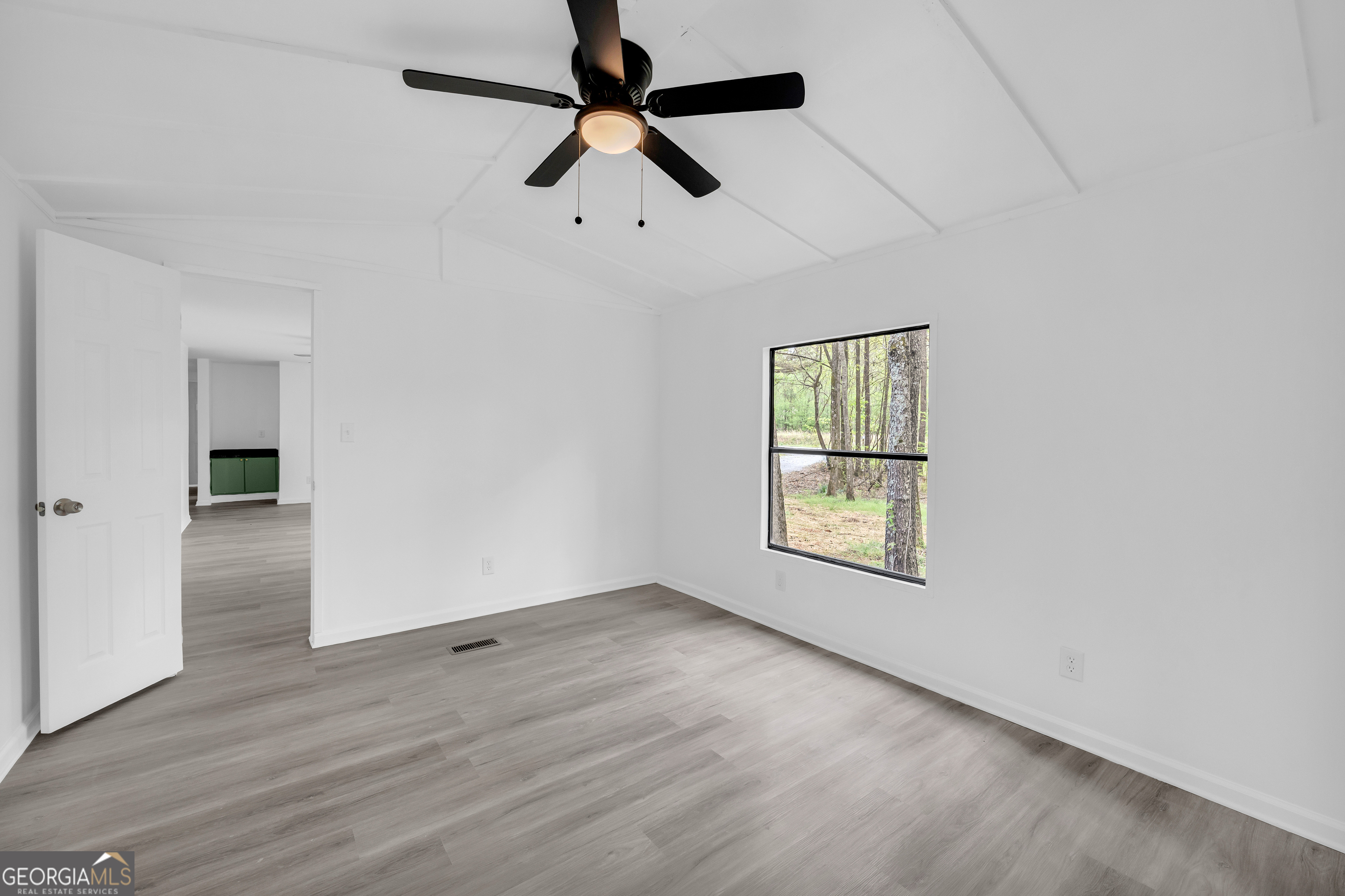 1144 Wolfskin Road Arnoldsville, GA 30619 - Photo 11 of 41 an empty room with wooden floor ceiling fan and windows