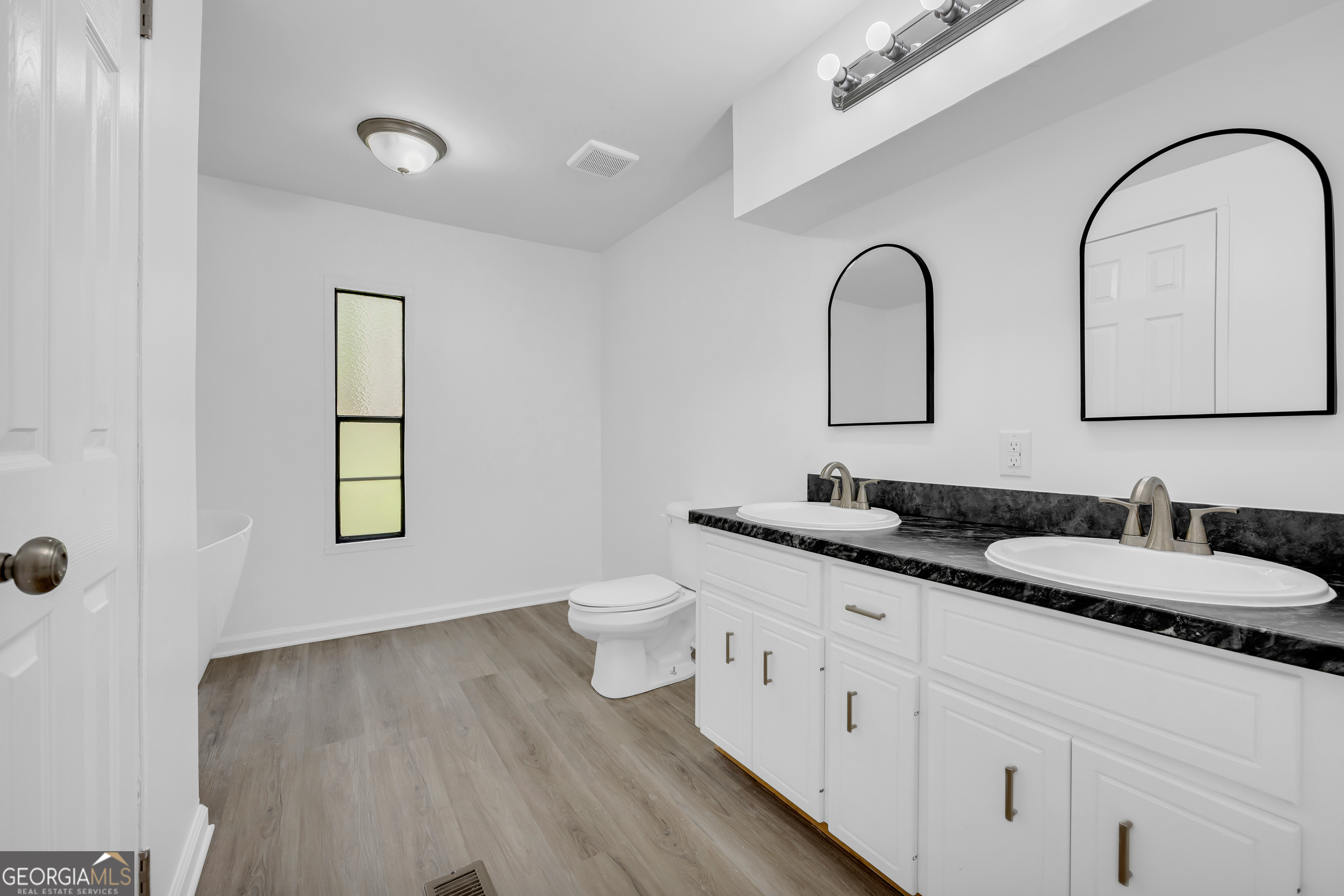 1144 Wolfskin Road Arnoldsville, GA 30619 - Photo 15 of 41 a bathroom with a granite countertop toilet sink and mirror