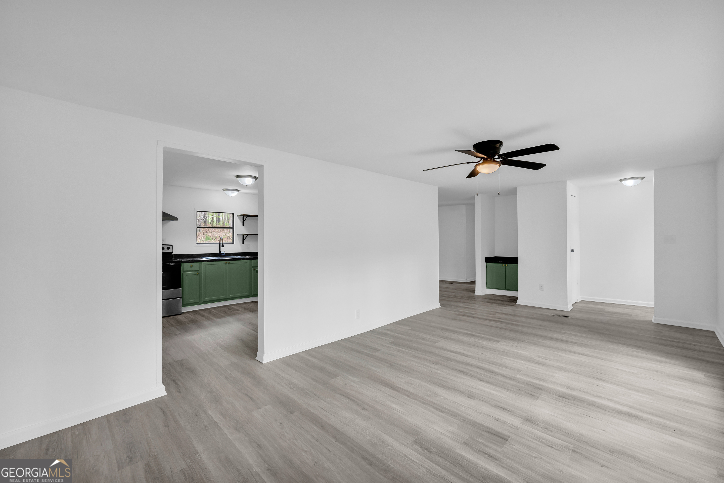 1144 Wolfskin Road Arnoldsville, GA 30619 - Photo 9 of 41 a view of an empty room with wooden floor and a ceiling fan
