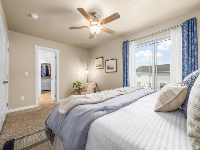 834 West 1050th Street South Springville, UT 84663 - Photo 13 of 26 Carpeted interior room featuring a ceiling fan with integrated lighting, a large window, and an open doorway leading to a walk-in closet