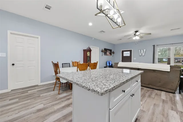 a kitchen with a table chairs and wooden floor