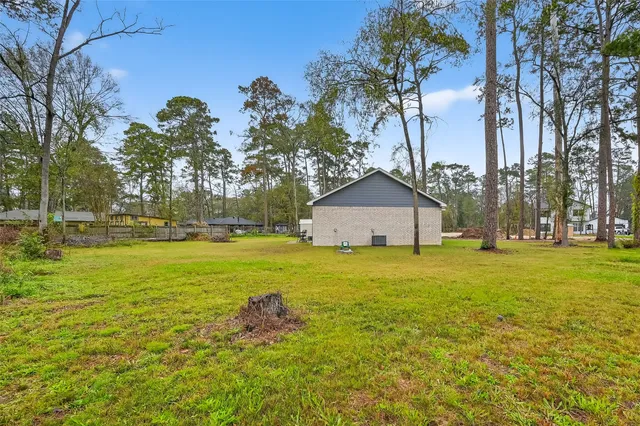a front view of a house with a garden and trees