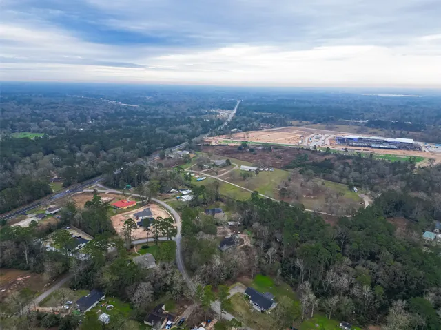 an aerial view of residential house with outdoor space and trees all around