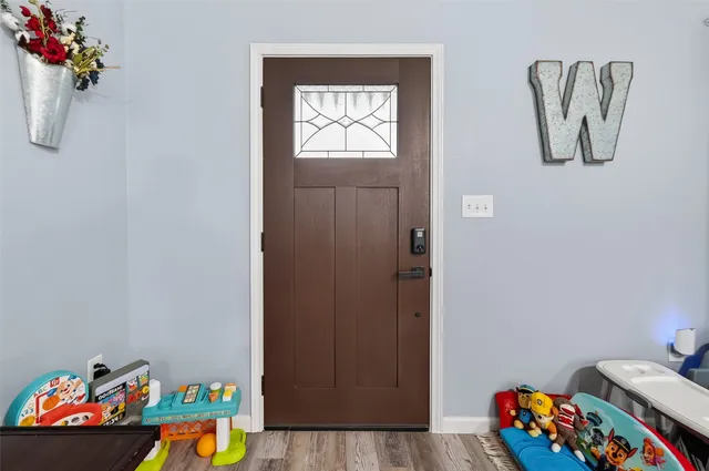 a living room with furniture kitchen view and a wooden floor