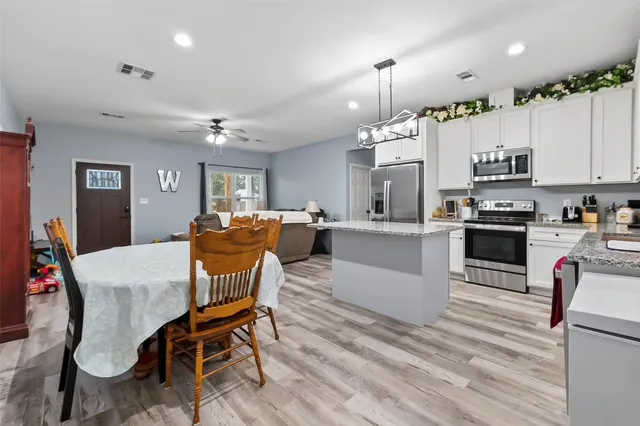a kitchen with stainless steel appliances granite countertop a sink stove microwave and refrigerator