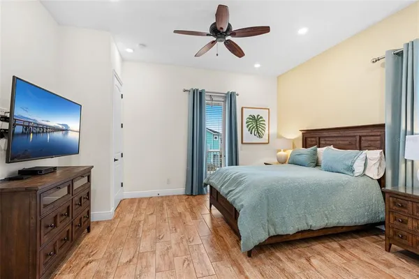 a bedroom with a bed and a flat tv screen on dresser