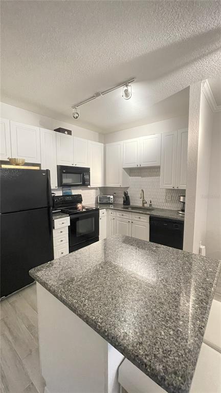 4221 West Spruce Street, Unit 1107 Tampa, FL 33607 - Photo 11 of 23 a kitchen with stainless steel appliances granite countertop a sink stove and refrigerator