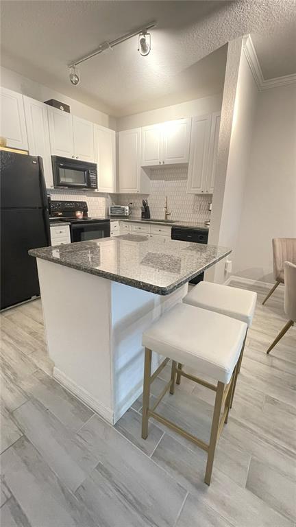 4221 West Spruce Street, Unit 1107 Tampa, FL 33607 - Photo 14 of 23 a kitchen with stainless steel appliances granite countertop a sink a stove a refrigerator white cabinets and wooden floor