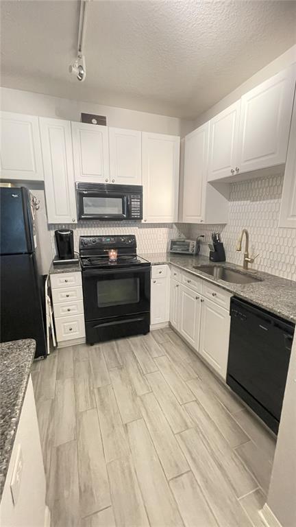 4221 West Spruce Street, Unit 1107 Tampa, FL 33607 - Photo 17 of 23 a kitchen with stainless steel appliances a sink a stove a microwave a sink a refrigerator and cabinets