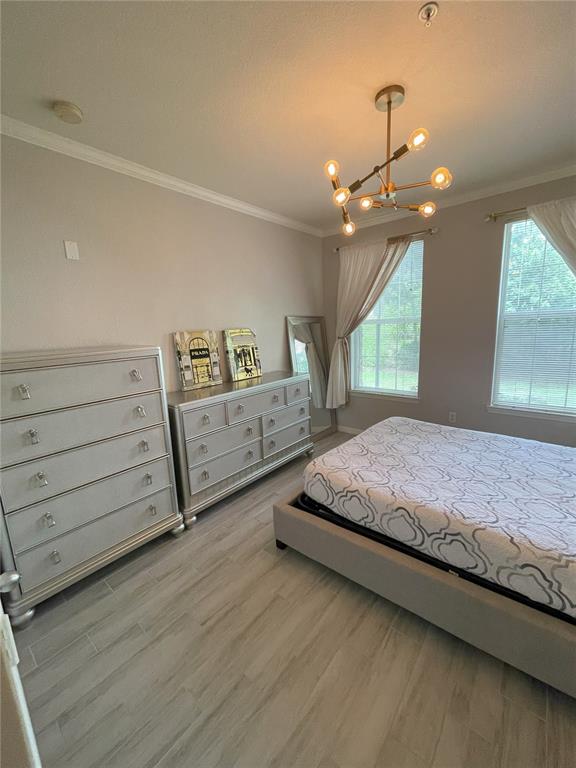 4221 West Spruce Street, Unit 1107 Tampa, FL 33607 - Photo 4 of 23 a bedroom with a large bed and a chandelier
