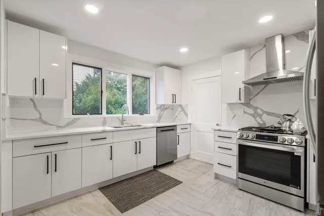 a kitchen with stainless steel appliances granite countertop a stove and a sink