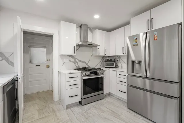 a kitchen with stainless steel appliances wooden floor sink and refrigerator