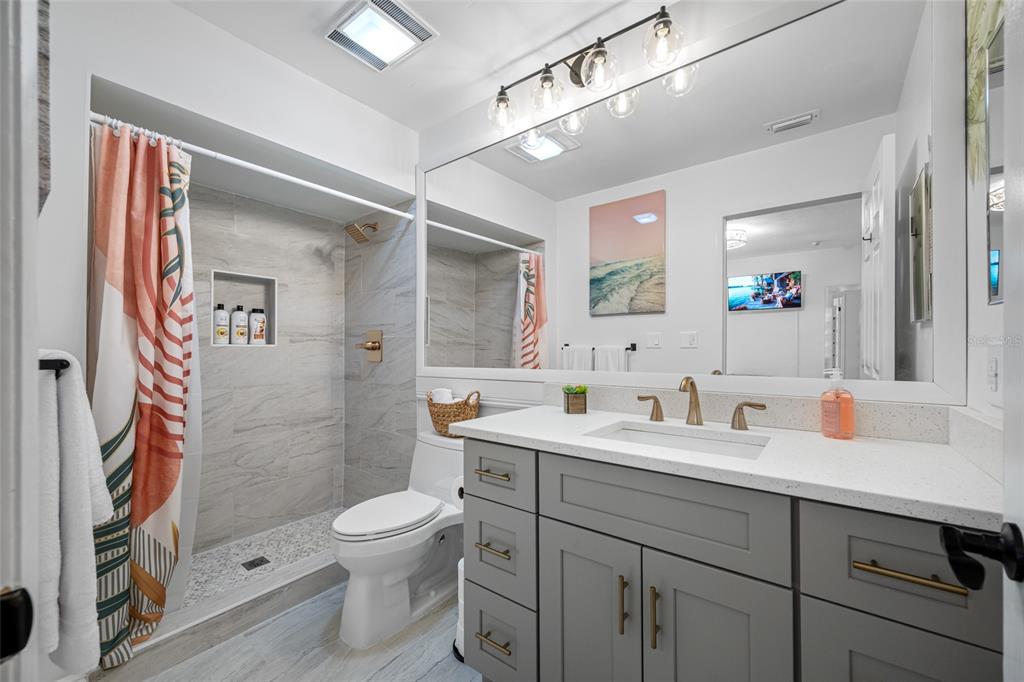 2153 Karan Way Clearwater, FL 33763 - Photo 28 of 65 a bathroom with a double vanity sink toilet mirror and shower
