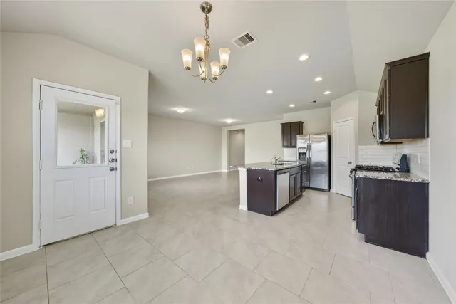 a large white kitchen with a large counter top stainless steel appliances and cabinets
