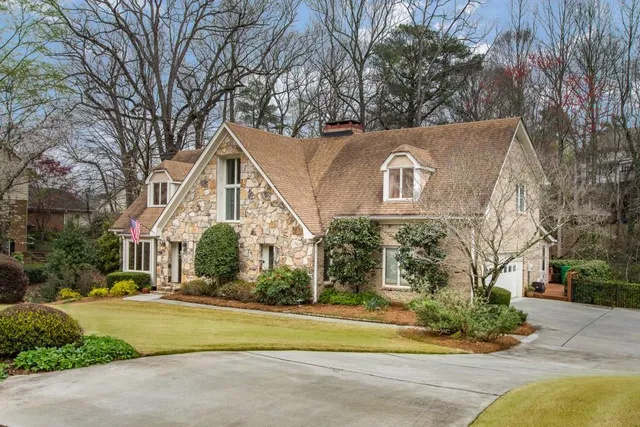 a front view of a house with a yard and trees