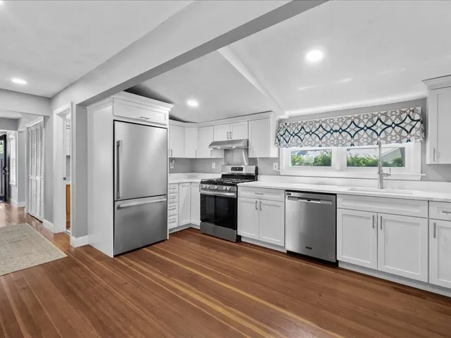 a kitchen with granite countertop a refrigerator and a sink