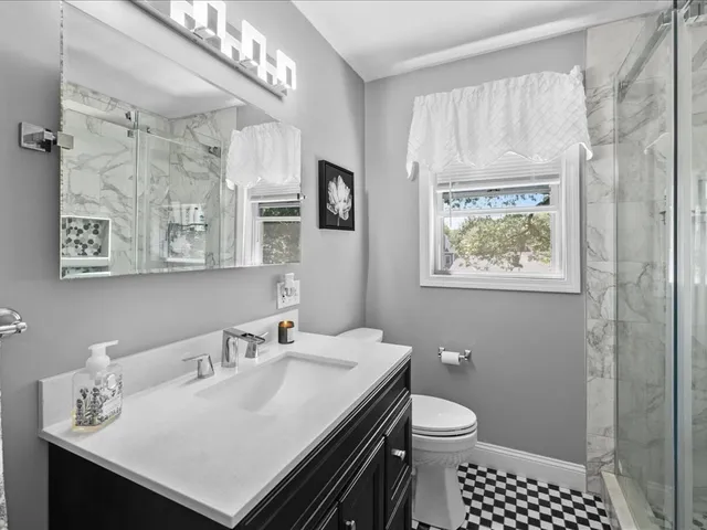 a bathroom with a sink a toilet and shower