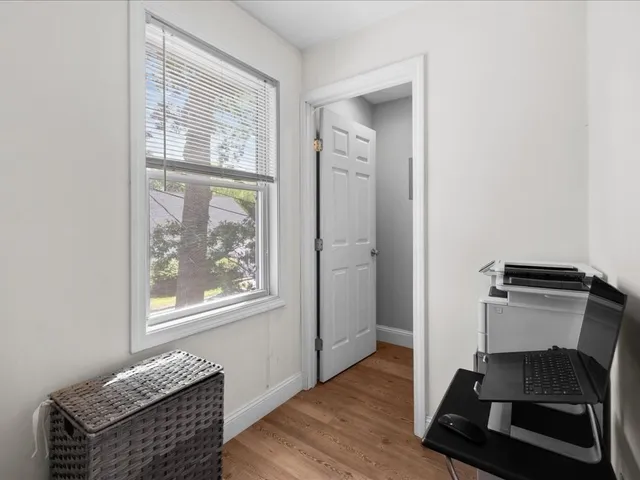 a living room with wooden floor and a window