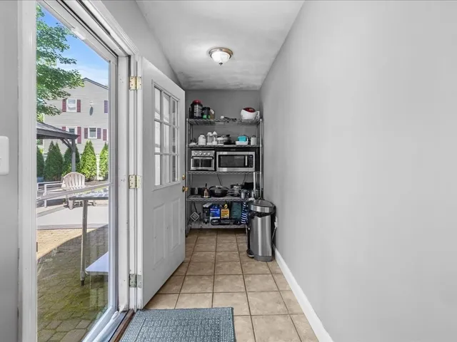 a view of a hallway with wooden floor and a living room