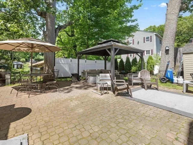 a view of a patio with a table and chairs under an umbrella