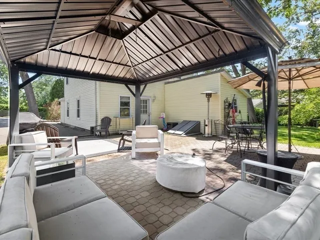a view of a patio with couches and chairs under an umbrella