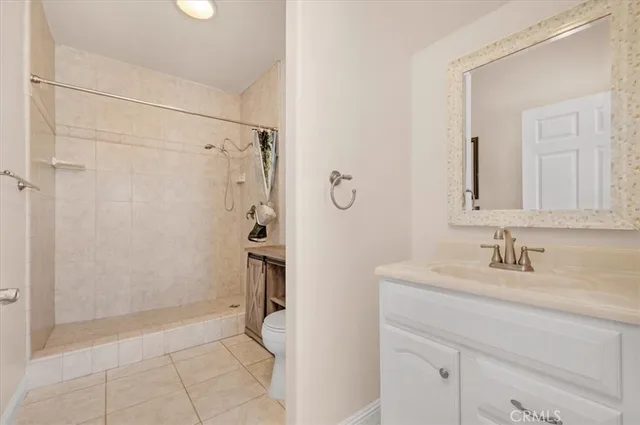 an empty room with a chandelier fan and a table