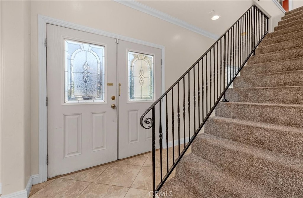 3271 East Muscat Avenue Fresno, CA 93725 - Photo 19 of 53 a view of an entryway with wooden floor leading to a furnished livingroom and windows