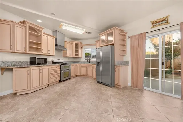 a kitchen with stainless steel appliances granite countertop a refrigerator and a stove top oven