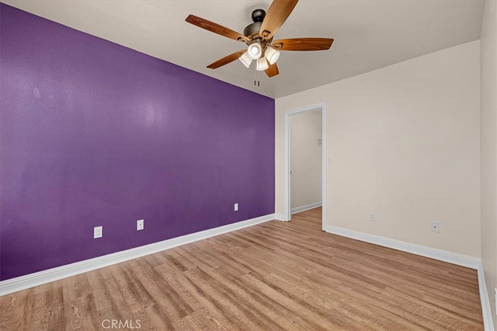 3271 East Muscat Avenue Fresno, CA 93725 - Photo 21 of 53 a view of a big room with wooden floor and a ceiling fan