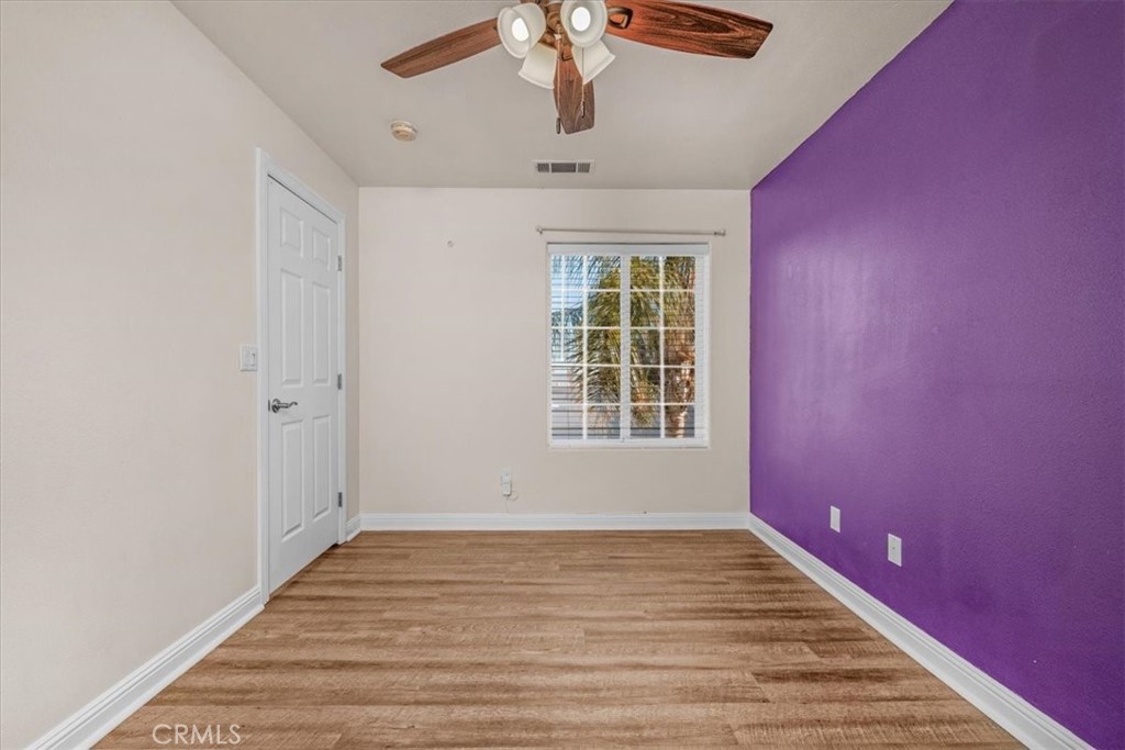 3271 East Muscat Avenue Fresno, CA 93725 - Photo 22 of 53 wooden floor in an empty room with a window