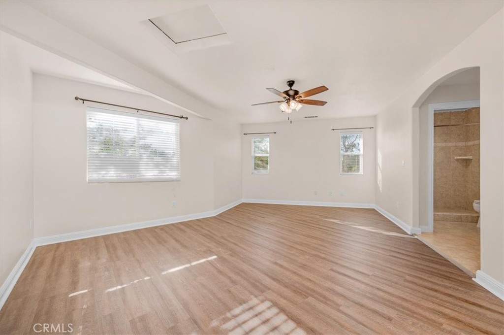 3271 East Muscat Avenue Fresno, CA 93725 - Photo 28 of 53 an empty room with wooden floor chandelier fan and windows